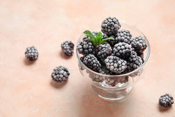 Frozen blackberry and mint leaves on beige grunge background