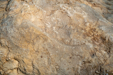 Closeup of the rough stone texture of a rock surface. Beige stone background. 