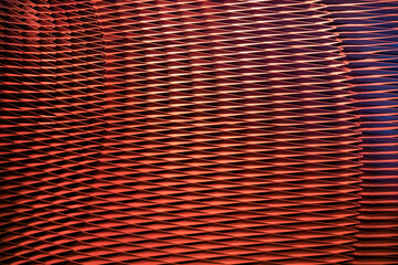 View to metal mesh facade, abstract background in red colour. 