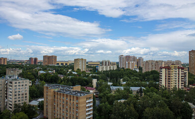Cityscape - panoramic top view of a residential quarter with modern high-rise buildings with green trees on a sunny summer day and blue sky with white clouds in Reutov, Moscow region and copy space