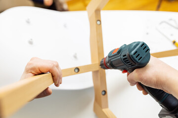 Craftsman collecting with tools, assembling furniture with screwdriver