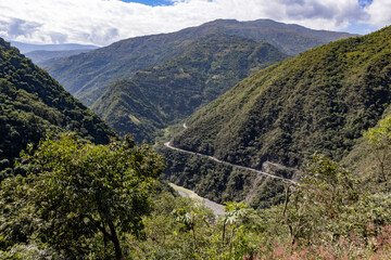 Scenic drive through the remote Bolivian Andes: passing small settlements, forested mountains,...