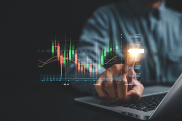 Investment strategy and progress concept. Trader's hand points at a virtual hologram stock on a screen, showcasing the path to business growth and success through strategic investment planning.