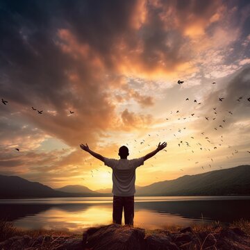 Man with open arms in front of a sunset and Beautiful sky.
