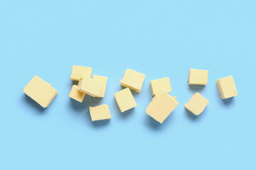 Pieces of fresh butter on blue background