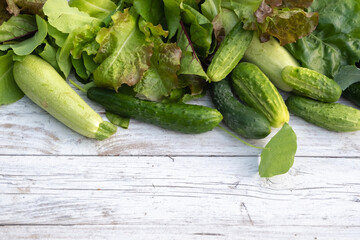 Many different green vegetables on a white wooden table. copy space. Top border