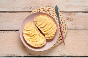 Plate of tasty toasts with butter on white wooden background