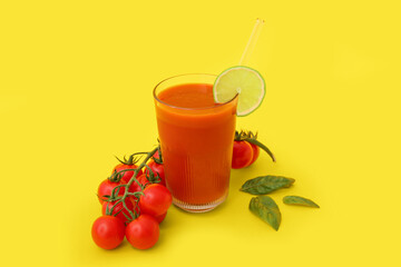 Glass of tasty tomato juice on yellow background