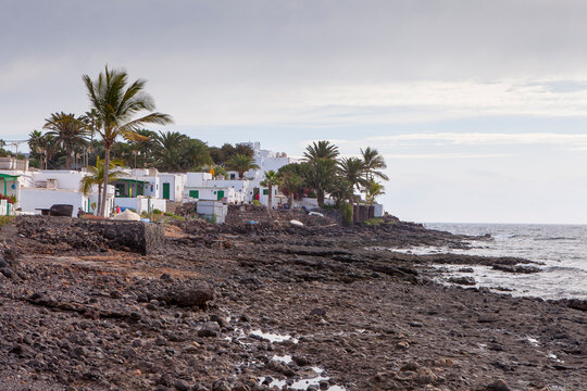 Casas en la playa de roca volcánica. Playa Quemada. Yaiza. Lanzarote. Islas Canarias. España.