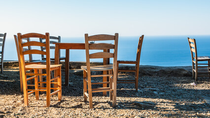 Gokceada (Imbros) coastline and a cute village tea garden view with wooden chairs and table. Tepeköy village, Çınaraltı-Pinarbasi location, Aegean Turkey