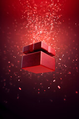 A small or tiny red gift box floating in the air with confetti and various particles flying out of the top. View from bottom to top. Birthday, Merry Christmas or New Year celebration concept