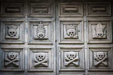 old wooden door in matera, skull, death, basilicata, italy, world heritage