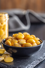 Lupini beans in brine. Pickled lupin in bowl on black table.