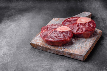 Fresh raw beef steak with bone or ossobuco with salt, spices and herbs