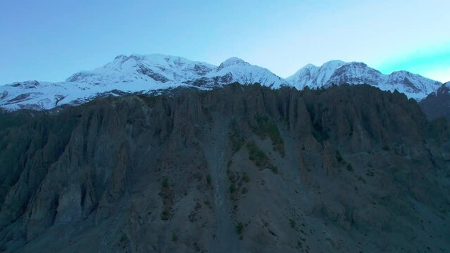 Aerial close up panning view Himalaya mountains with snowy peaks and sun behind mountain. Majestic breathtaking Nepal Himalayas mountains background.