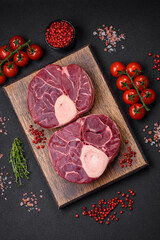 Fresh raw beef steak with bone or ossobuco with salt, spices and herbs