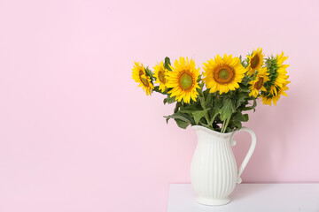 Vase with sunflowers on shelf near pink wall © Pixel-Shot