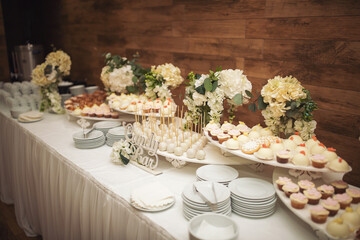 Delicious sweet buffet with cupcakes. Sweet holiday buffet with cupcakes and other desserts. Candy Bar. Dessert table for party goodies. Party reception, decorated delicious in the restaurant.