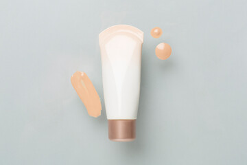 Composition with makeup foundation on color background, top view