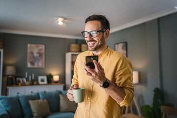 One adult man with eyeglasses stand at home use mobile phone talk