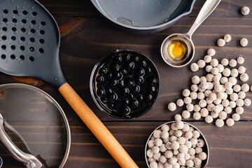 Cooked Boba in Syrup Surrounded by Utensils: Quick cook boba pearls with a small saucepan and other kitchen equipment