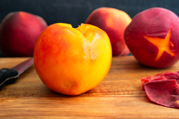 Fototapeta na wymiar Peeled Peach on a Wood Cutting Board: Side view of a peeled peach on a wooden table