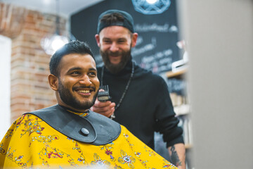 Happy Indian male client after a haircut with a barber behind him in barbershop. High quality photo - Powered by Adobe
