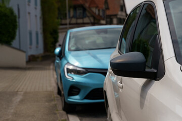 White and blue cars are parked on the street of a small German town