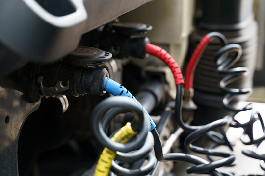 Connecting pneumatic and electrical hoses and cables to a truck semi-trailer