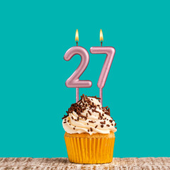 Birthday card with number 27 candle on aquamarine background