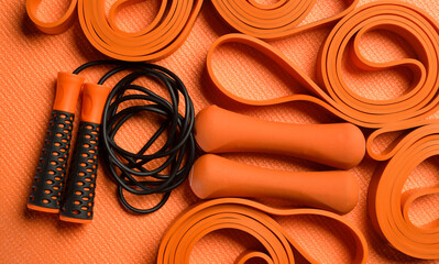 composition with orange fitness accessories on orange background for background banner