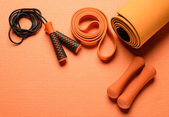 composition with orange fitness accessories on orange background for background banner