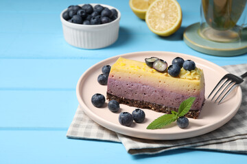 Delicious cheesecake with blueberry and mint on light blue wooden table. Space for text
