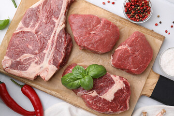 Flat lay composition with cut fresh beef meat and spices on white table