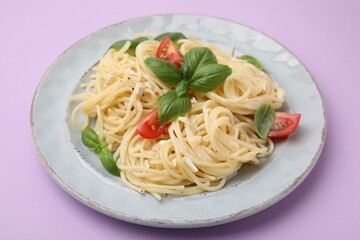 Delicious pasta with brie cheese, tomatoes and basil leaves on violet background, closeup