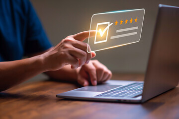 Customer rating and satisfaction concept, Man using laptop and touch virtual screen for give five star symbol to increase rating of product and service concept.