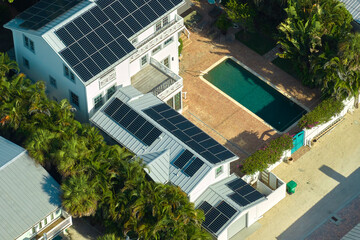 Aerial view of new expensive american home roof with blue solar photovoltaic panels for producing clean ecological electric energy. Renewable electricity with zero emission concept