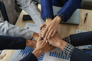 Obraz premium Large business teams show unity with their hands together, a group of businessmen and women join hands to express joy in working for the success of projects in the office. Remote Picture