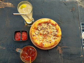 Portrait of delicious pizza, cold drinks, and fresh tomato sauce Tempting at the Table