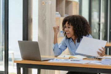 African american girl working at office with laptop and financial document calculator excited about success with arms raised and to celebrate victory with smile.