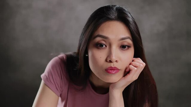 Young Asian woman in a studio doing some gestures for a photo shooting - extreme slow motion