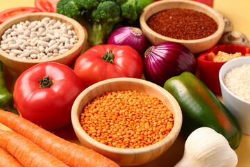 Different fresh vegetables and cereals on yellow background, closeup