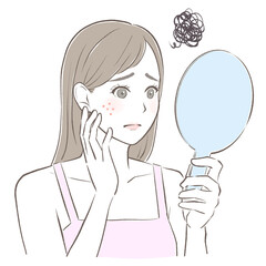 手鏡を見てニキビに悩む女性　