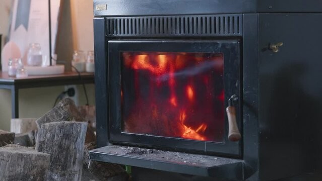 Roaring fire inside living room fireplace; locked-off crash zoom