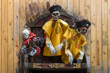 Skeletons dressed in traditional chinese outfits and hats.