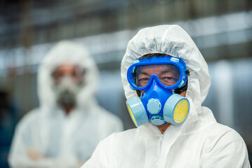 Male inspector team investigate danger chemical gas leak spill with safety face mask PPE suit in...