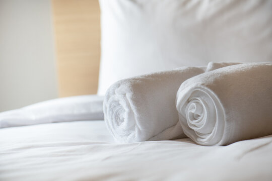 Soft pillows and white towel on clean white bed. Pillows bed with bedding sheets in bedroom. Bed sheets and pillows messed. Hotel, resort or home can relax on bed for deep sleep.