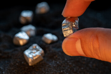 The hands of men are holding at the silver or platinum  or rare earth minerals ore in their hands...