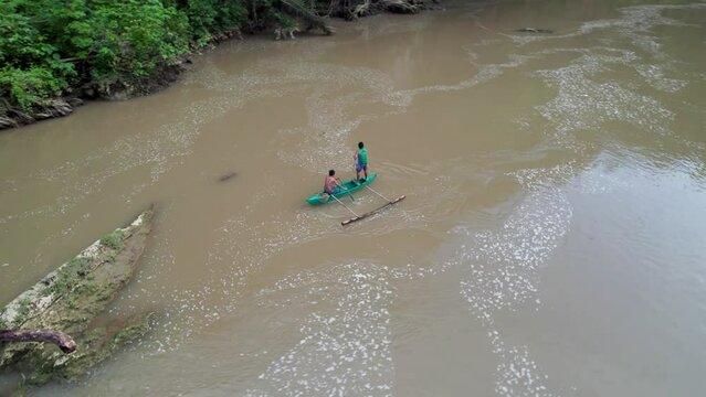 P&ecirc;cheur traditionnels philippins sur un bateau traditionnel sur une rivi&egrave;re marron au milieu de la jungle sauvage et des rochers sur l'ile de Bohol aux Philippines
