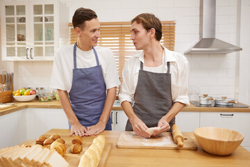 LGBT gay couple making a bread together in the kitchen